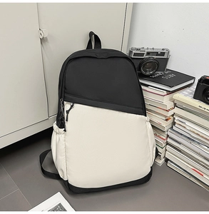 Detailed view of a black and beige contrast canvas backpack against a vintage camera