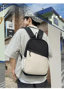 Close-up of a waterproof nylon backpack with contrast stitching on a street model