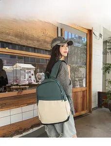 Deep green and cream nylon backpack shown on model standing by a cafe wooden door