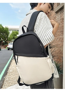 Detail of waterproof nylon backpack showing black and beige contrast and side pocket