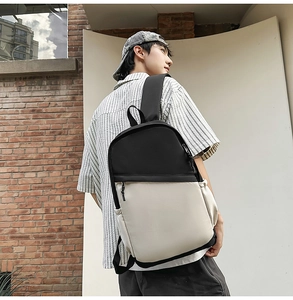 Detailed view of color-block nylon backpack with side pocket and sturdy black handle