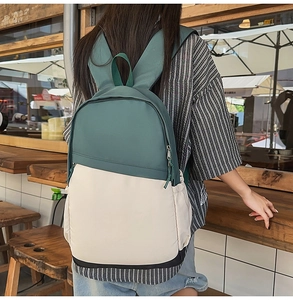 Rear view of color-block nylon business backpack with side pockets in a cafe setting