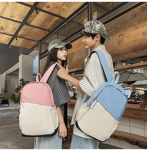 Detail of color-block nylon backpack featuring durable black bottom and ribbon zippers