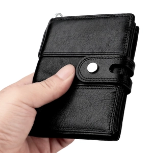 Close-up of black genuine leather wallet showing pebbled texture and metal snap closure
