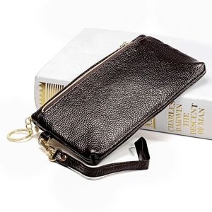 Dettaglio della pochette in pelle marrone scuro con grana litchi e zip in metallo dorato