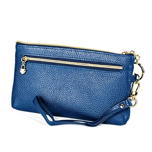 Dettaglio portafoglio in pelle blu scuro con cerniera a cuore dorata e cinturino da polso