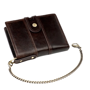 Detail of genuine cowhide leather wallet with vintage brass anti-theft chain and clasp