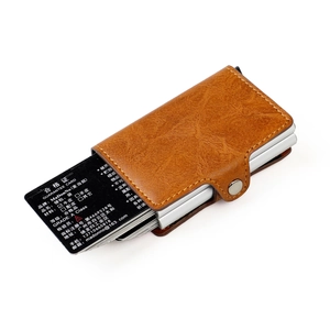Close-up of brown pebbled leather card holder with automatic aluminum RFID card ejector