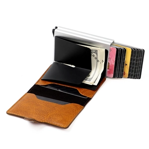 Detail of RFID-blocking aluminum pop-up card holder with brown leather and cash strap