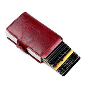 Detail of red leather RFID wallet with silver aluminum pop-up card holder and snap closure
