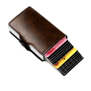 Macro view of brown leather RFID wallet showing automatic pop-up metal card slot mechanism