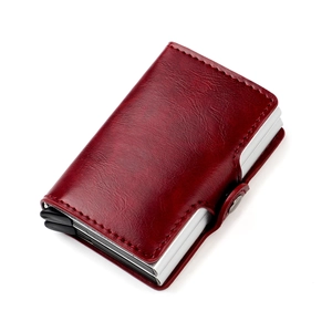 Close-up of dark red leather wallet texture with silver metal frame and secure snap button