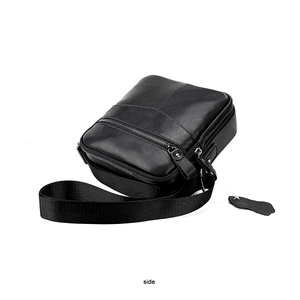 Side view of black leather crossbody bag showing smooth texture and adjustable strap