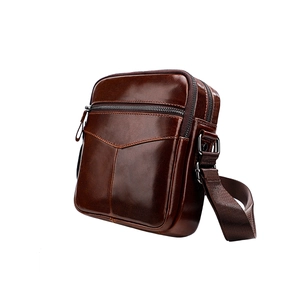 Detail view of deep brown leather men's chest bag with metal buckle and shoulder strap