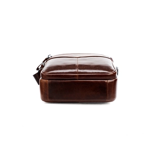 Close-up of bottom stitching and oily wax texture on brown leather crossbody bag