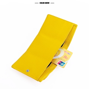 Detail view of yellow lychee leather wallet with card slots and metal snap closure