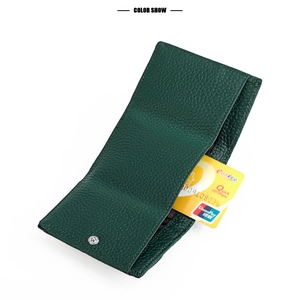 Detail view of dark green leather wallet with pebbled texture and metal snap button