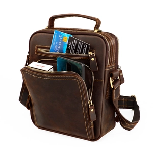 Detailed close-up of dark brown crazy horse leather bag with multiple zipper compartments