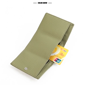 Detail of sage green pebble leather wallet with precise stitching and metal snap button