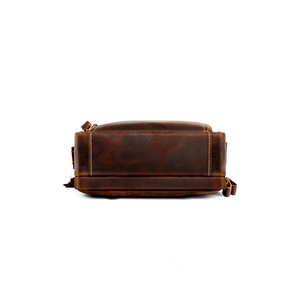Close-up of vintage brown leather bag bottom with reinforced yellow stitching details