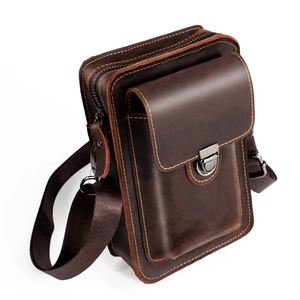 Dettaglio borsa in pelle marrone vintage con cuciture gialle e fibbia in metallo scuro