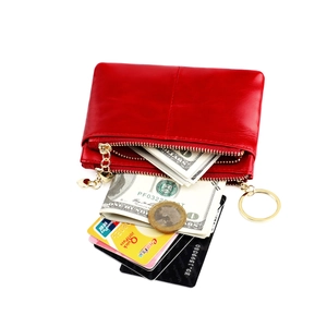 Detail of red wax leather coin purse with double heart zippers and golden key ring hook