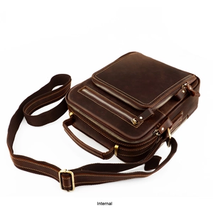 Macro view of the internal storage compartments in a vintage brown leather messenger bag