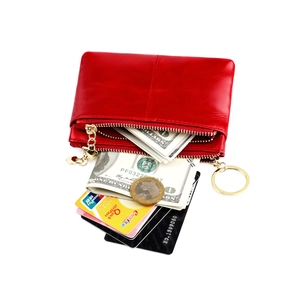 Detail of red leather coin purse with double zippers, gold heart charms, and key ring