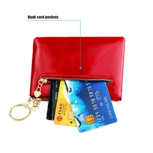 Detail view of red oil wax leather coin purse showing bank card pockets and gold zipper