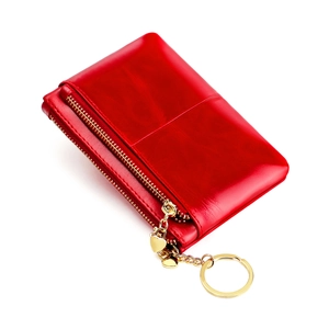 Detail of red wax leather coin purse with double zipper and gold heart-shaped charm