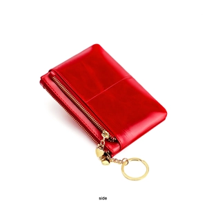 Detailed side view of red wax leather coin purse with double gold zippers and heart charm