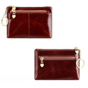 Detail view of brown oil wax leather coin purse with heart pendant and gold hardware