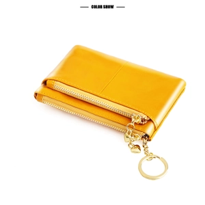 Detail of yellow oil wax leather coin purse with double zippers and heart keychain