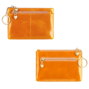 Detail of bright orange oil wax leather coin purse with heart pendant and gold hardware