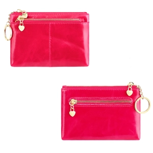 Detail of red wax leather coin purse with double zippers, heart charms and gold keychain
