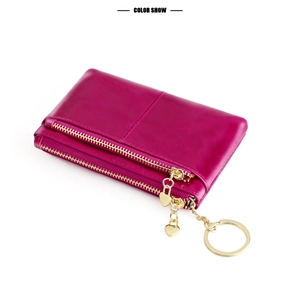 Detail of rose red oil wax leather coin purse with double zippers and heart pendant