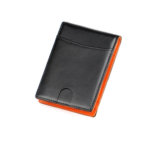 Detail of slim leather wallet with black lychee texture and orange lining thumb slot
