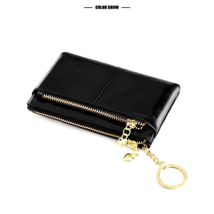 Close-up of black oil wax leather coin purse with double gold zippers and heart charm