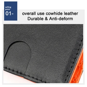 Detail of slim leather wallet showing textured black cowhide and bright orange lining