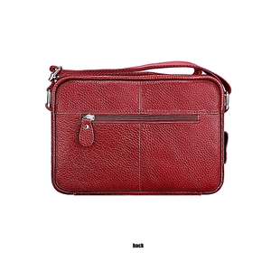 Detail view of red lychee grain leather crossbody bag back with zipper pocket