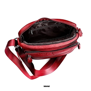 Detail shot of the internal compartments and red lychee texture of the leather handbag