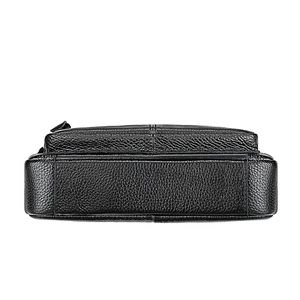 Close-up detail of genuine black litchi pattern leather on women's shoulder bag base
