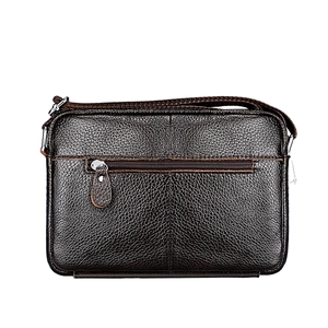 Detail of dark brown lychee grain leather texture on shoulder bag with front zipper pocket