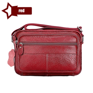 Detailed view of dark red lychee grain leather handbag with multiple zipper pockets