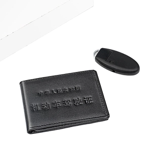 Détail de l'étui à permis en cuir noir avec texture embossée et clé de voiture