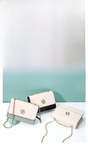 Détail du cuir de vachette véritable et du logo métallique doré sur le sac à chaîne chic