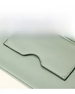 Détail du sac en cuir vert sauge montrant les coutures fines et la finition des bords