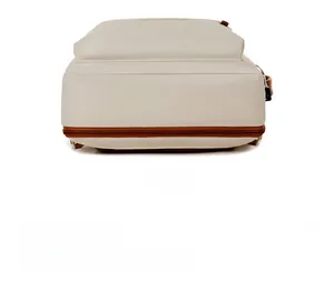 Close-up of the reinforced bottom with brown zipper detail on the cream oxford backpack