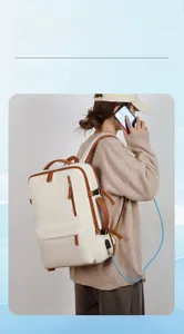Detail of minimalist laptop backpack featuring side handle and USB charging port