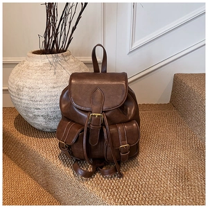Detalle de mochila de cuero vintage marrón oscuro con bolsillos con hebilla en fondo interior